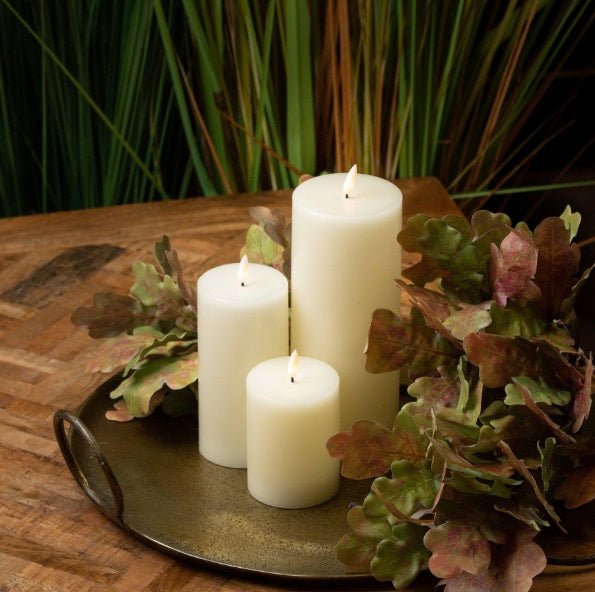 LED candles on tray with artificial foliage decorated around them