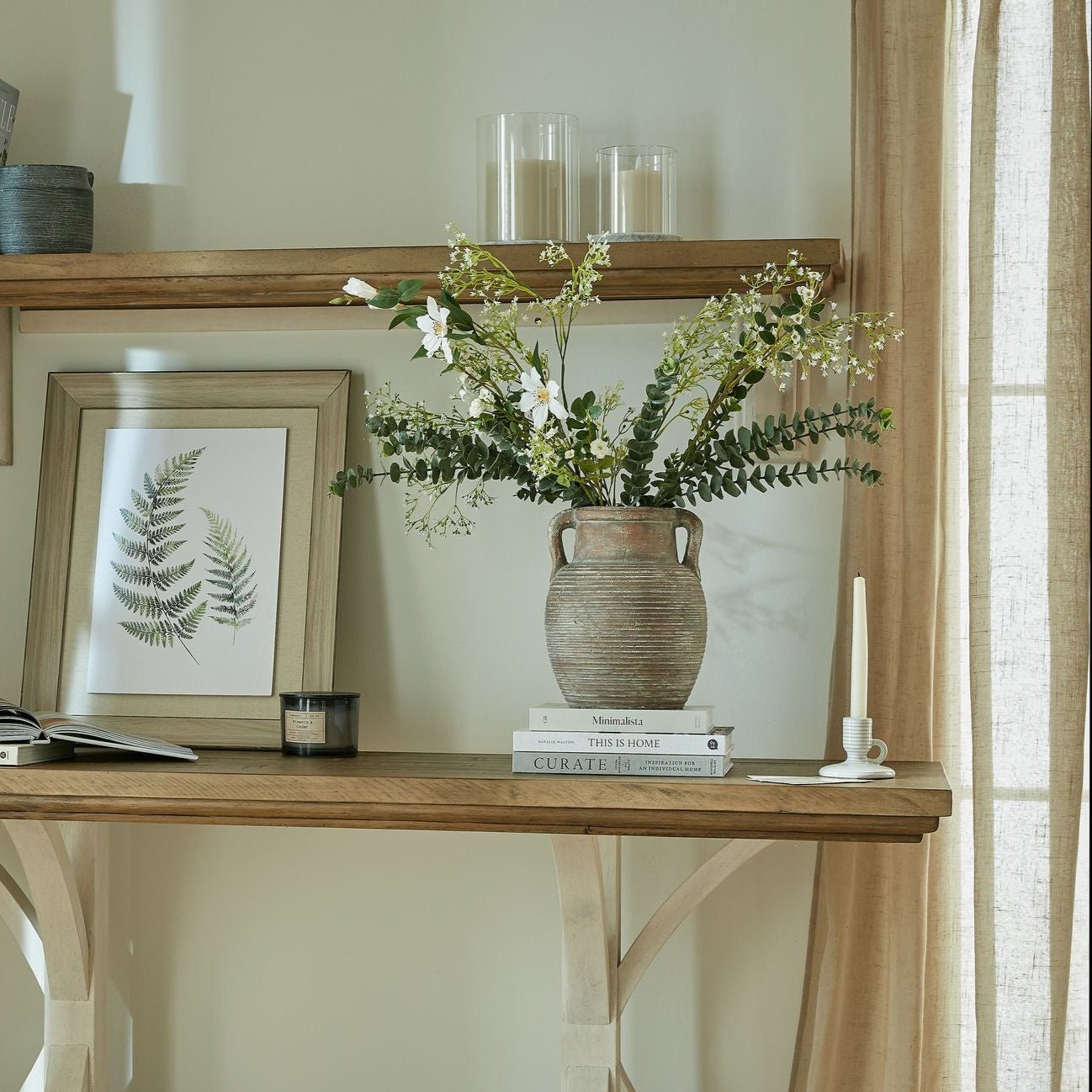 Amphora Pot on console table with artificial flowers in