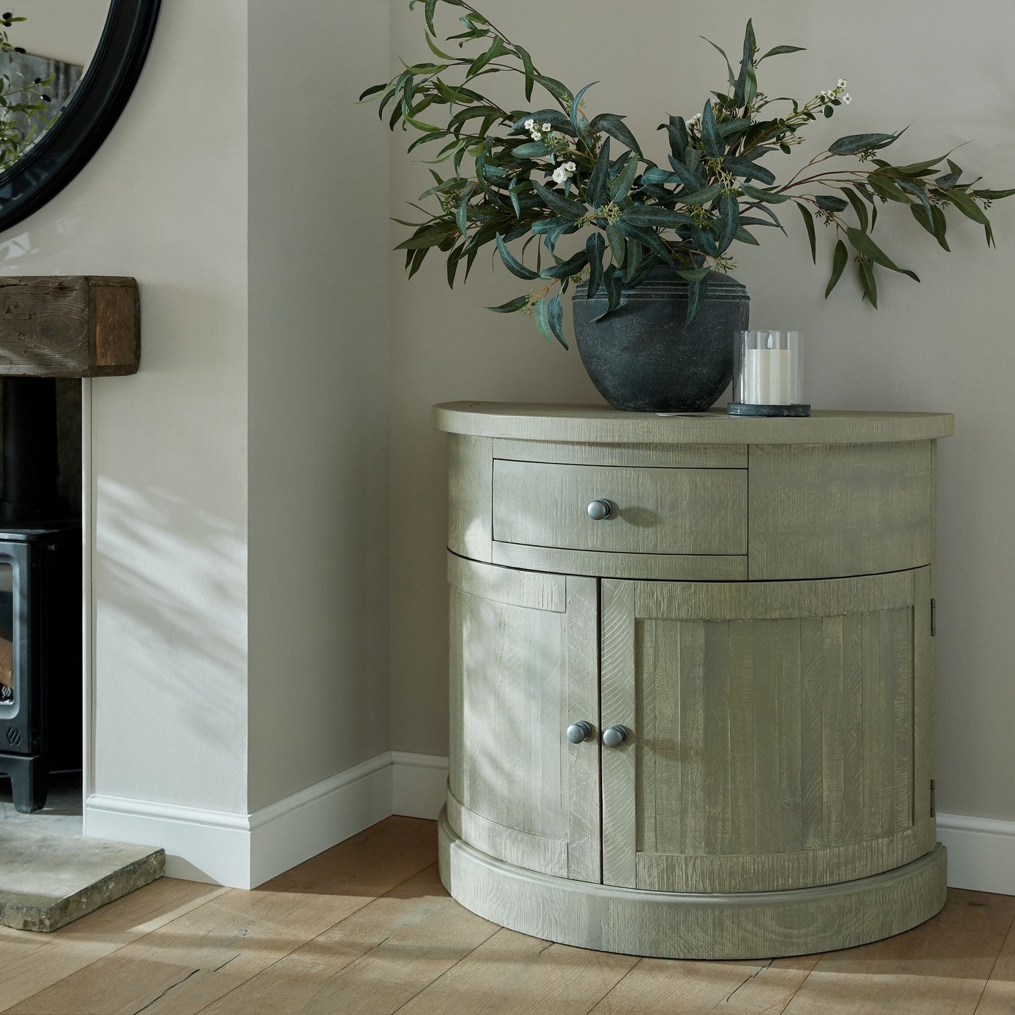 half moon sideboard with artificial branches and candle on top