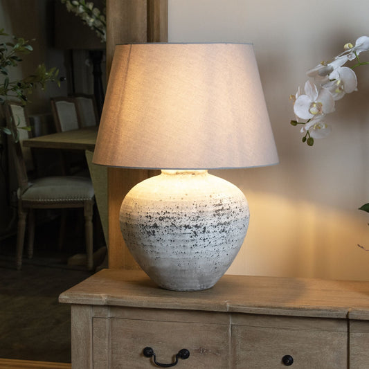 stone table lamp with linen shade on sideboard