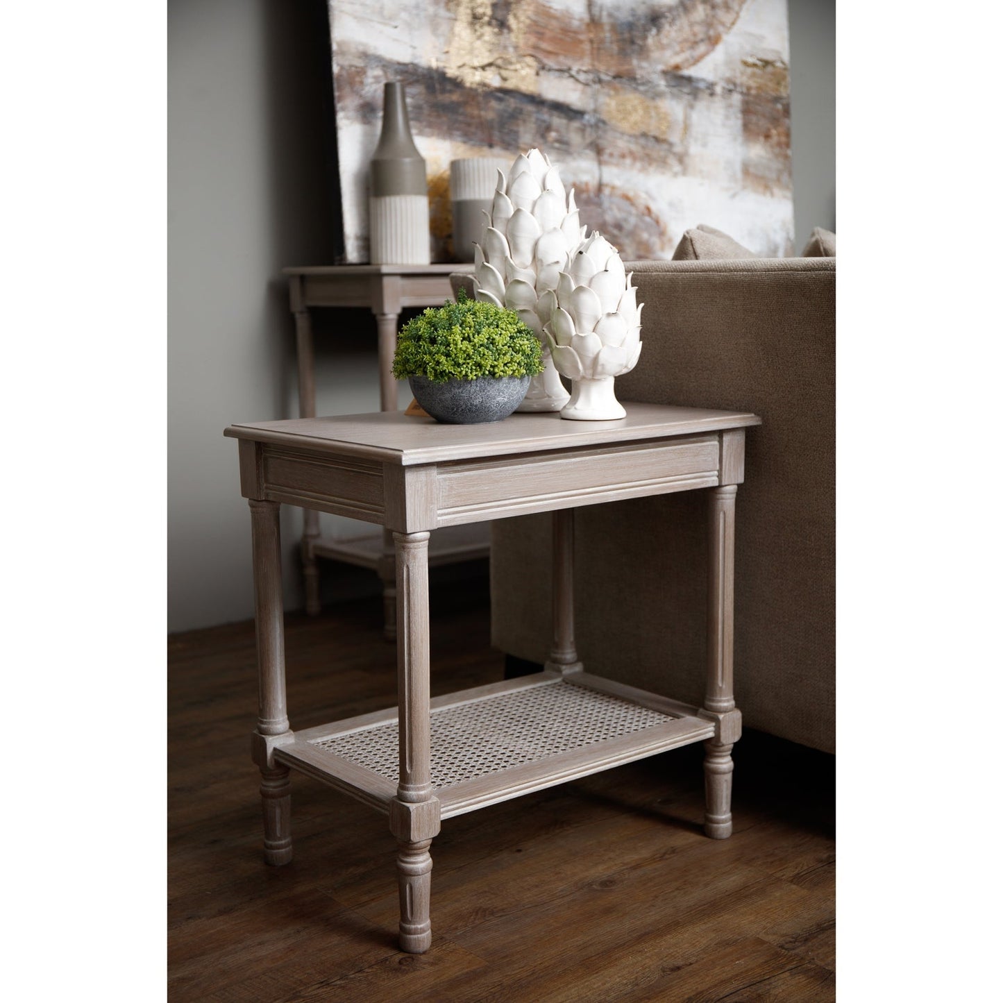 side table next to sofa with artificial plant and decor on top