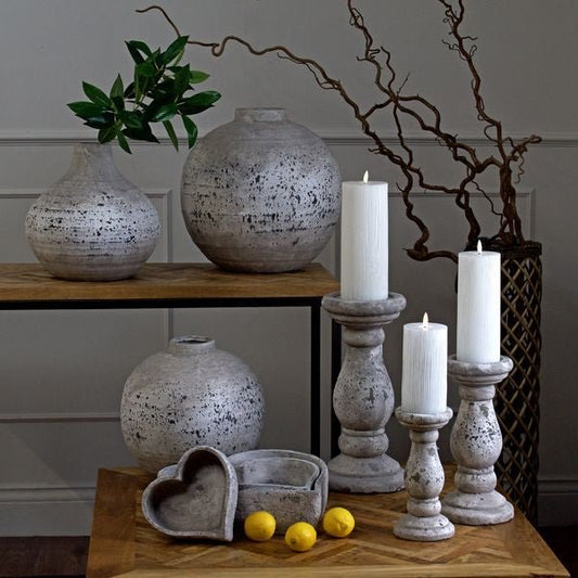 All 3 Aged Stone candle holders displayed with ribbed LED Flameless candles, and aged stone vases, both small and large globe and amphora style