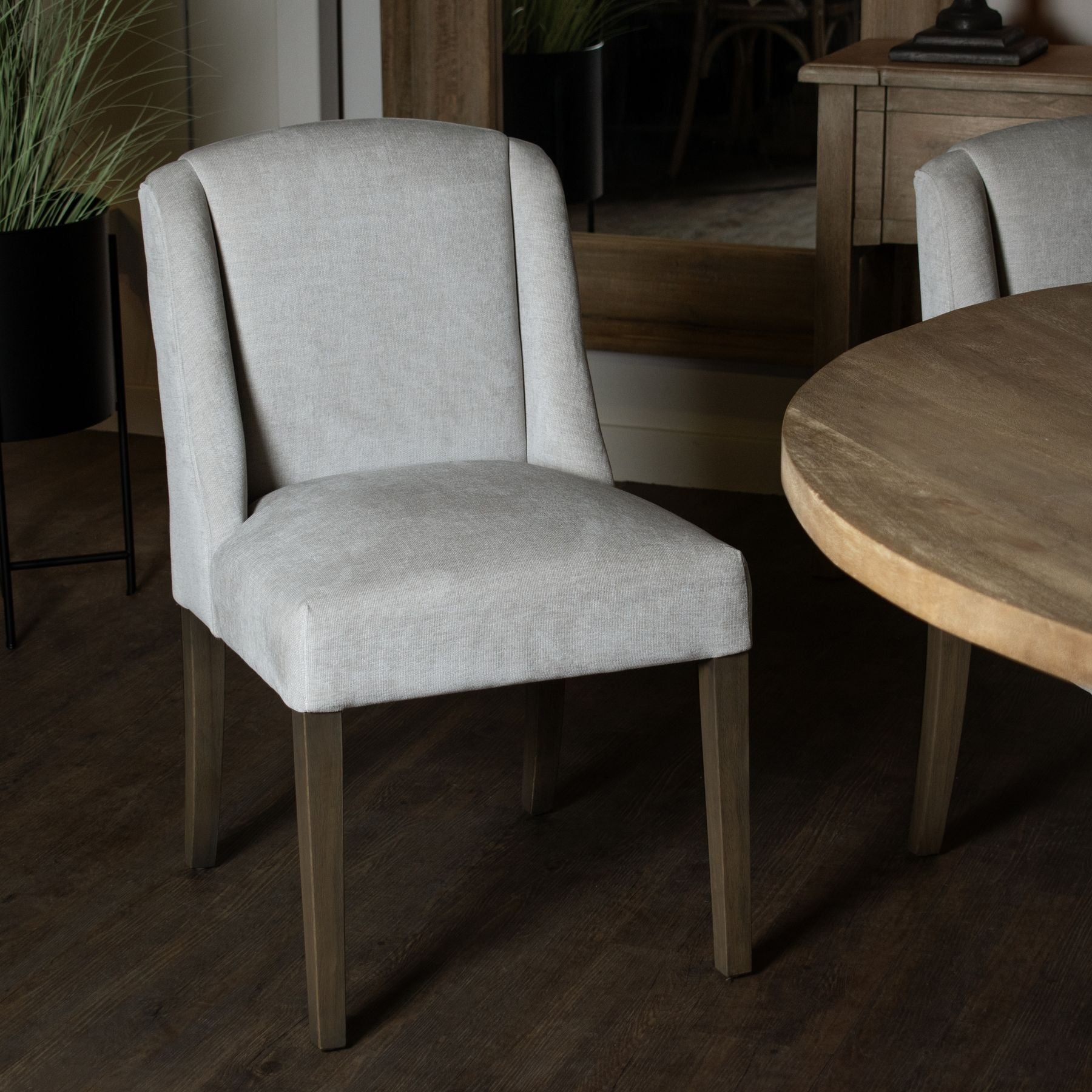 lifestyle image of the chelsea dining chair, a round dining table can be seen to the right