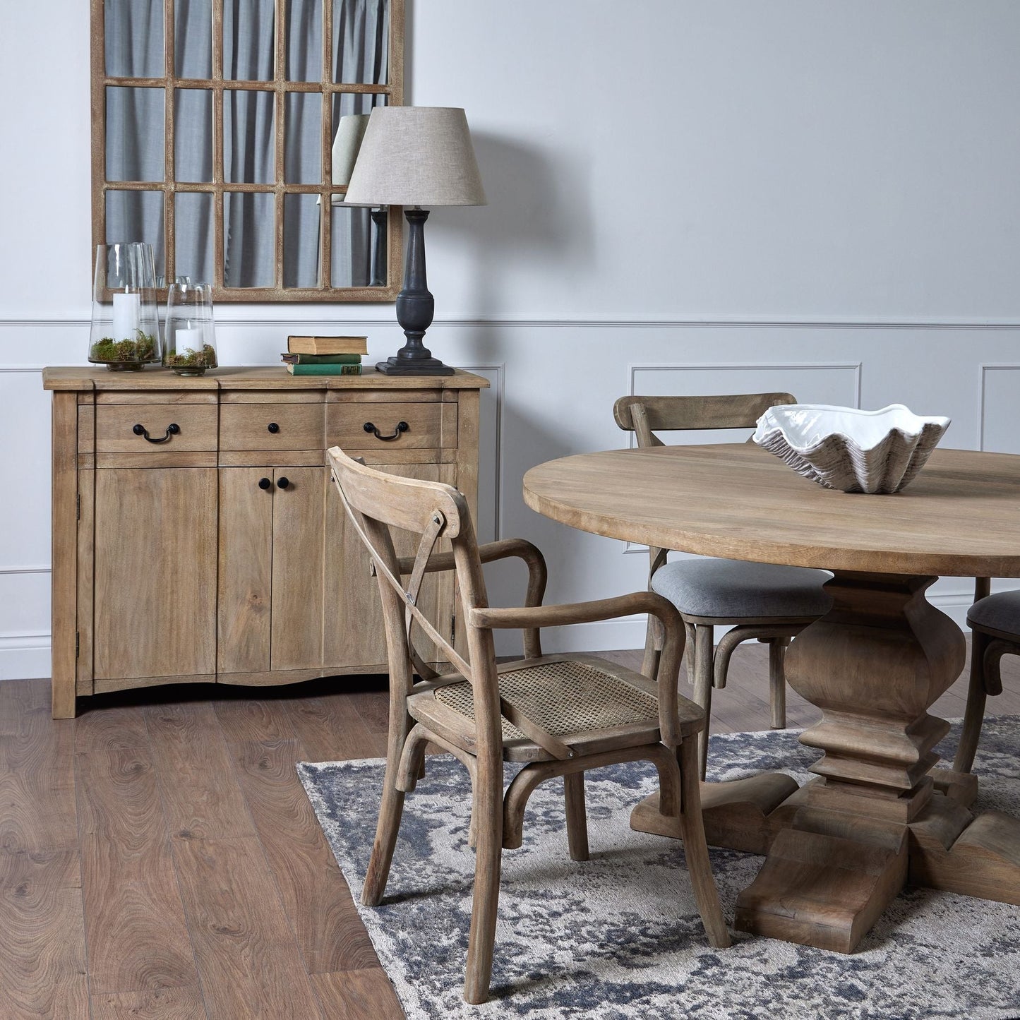 room set, sideboard in the background with round dining table in the foreground with clam shell bowl in the centre