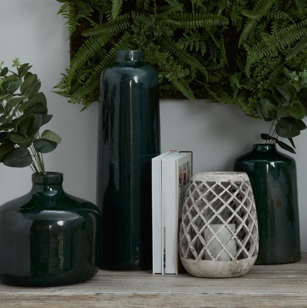 conical shaped aged stone hurricane lantern with glazed green vases or varying styles and height