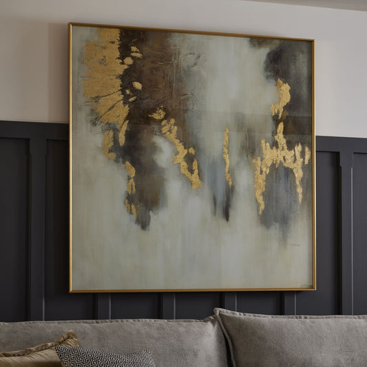 gold wall art on panelled wall behind sofa