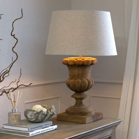 lifestyle image, natural wash fluted lamp with linen shade on sideboard. Decorative books a clamshell bowl and reed diffuser are to the left.