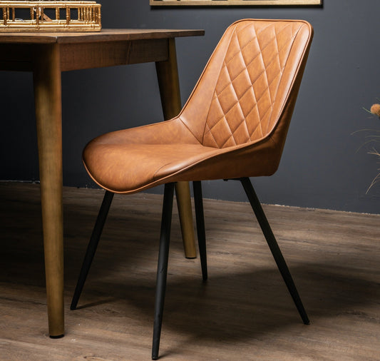 tan vegan leather dining chair on black legs, diamond stitch detail to the back of the chair. Placed next to dining table