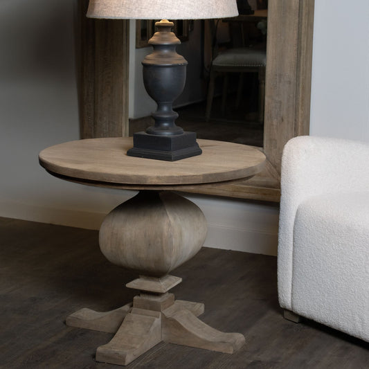 round side table with large lamp on top, mirror behind